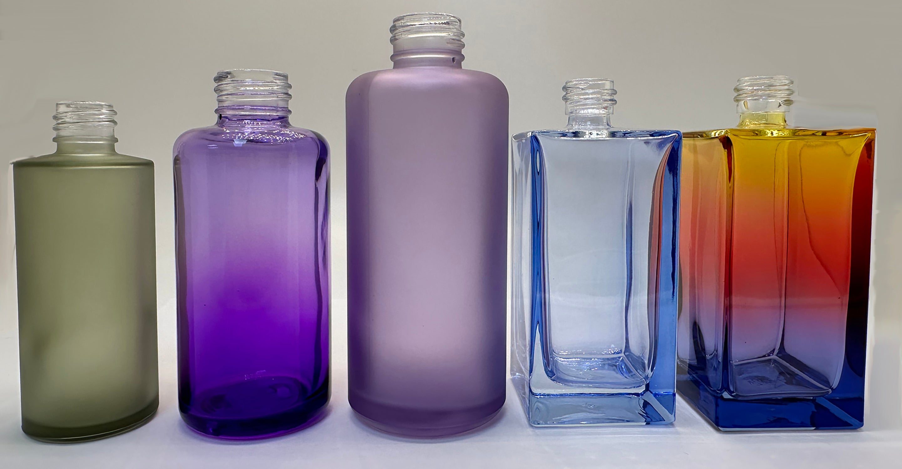 Colorful glass bottles and jars with varied finishes
